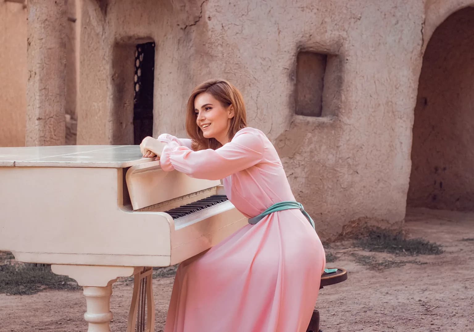 La pianiste Irina Grebaus devant un piano à queue blanc